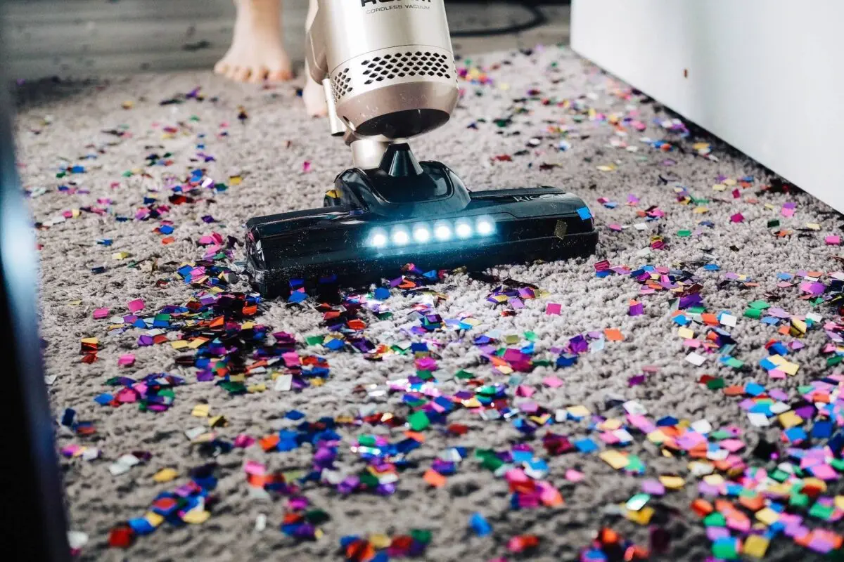 Care-Arbeit: ein Staubsauger saugt glitzerndes Konfetti vom Boden